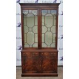 A reproduction mahogany George III style bookcase with two glazed doors and shelves above two