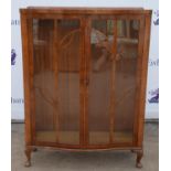 Walnut serpentine display cabinet, glazed doors, shelves present but not photographed,