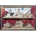 A diorama, probably early 20th Century, made up of various dolls within an interior setting,