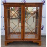 Reproduction yew wood serpentine bookcase with glazed doors and lined interior, shelves present not