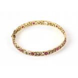 Antique floral cut out bangle, set with round cut rubies and seed pearls, mounted in 9 ct yellow