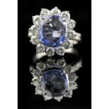 Sapphire and diamond cluster ring, central claw set cushion cut sapphire weighing an estimated 4.