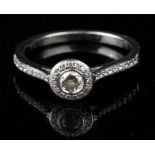 Diamond halo ring, central round brilliant diamond weighing an estimated 0.15 carat,
