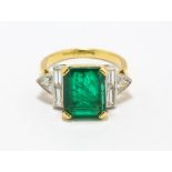 An emerald and diamond ring, centrally set with a step-cut emerald, estimated weight 3.15 carats,