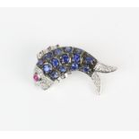 Fish brooch, body set with round cut sapphires with a diamond set head and tail and a ruby eye,
