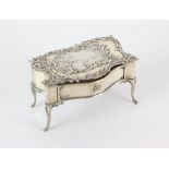Miniature silver rococo table cast with a vignette of a formal garden within foliate scrolls,