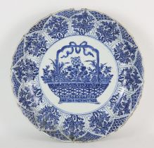A Chinese blue and white dish decorated with a central design of a flower arrangement in a basket;