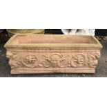 Reconstituted stone trough moulded with masks and griffon. H30 x W76 x D24cm