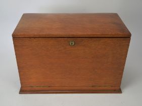 Edwardian oak stationary cabinet, with two brass carrying handles, opening to reveal an arrangement