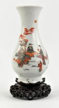 A Chinese vase with trumpet neck, decorated in black and orange with a seated scholar and three