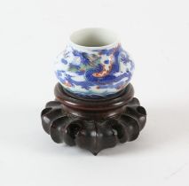 A small vase, possibly a bird feeder, decorated in underglaze blue and other colours with a dragon