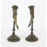 Pair of French bronze candlesticks, each with drinking horn sconces, on baluster stems,