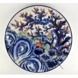 A Japanese Imari dish, decorated with birds in a tree, foliage and rock work, 59cm diameter,