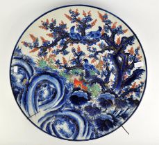 A Japanese Imari dish, decorated with birds in a tree, foliage and rock work, 59cm diameter,