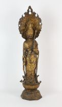 A gilded metal figure of a Buddhist Deity, standing on a lotus base with removable flaming mandala