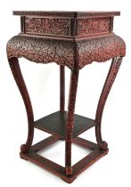 A red lacquer stand on four legs, decorated on the exterior with dense floral patterns; the square