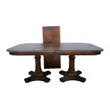 A walnut twin pedestal dining table, with parquetry top, on turned columns, each with quatrefoil