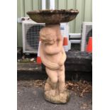 Reconstituted stone bird bath supported by a naked cherub, H74cm