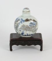 A Chinese snuff bottle decorated with figures in a narrative scene, the base with underglaze blue