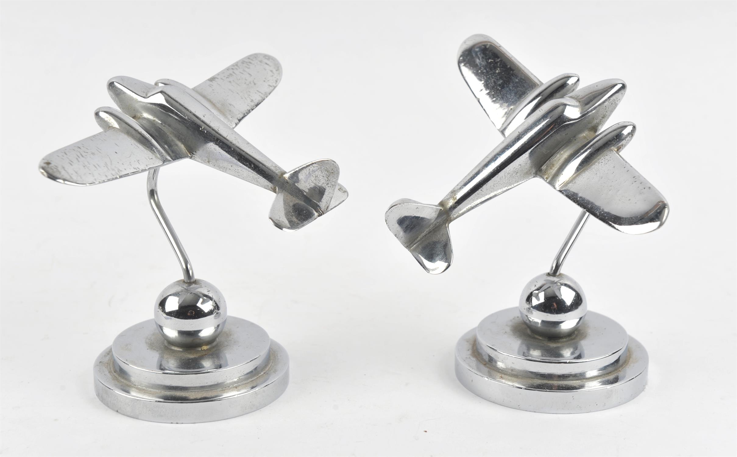 Pair of Art Deco aluminium desk ornaments cast as twin engine aircraft, on stepped base,