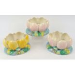 Three Clarice Cliff rose or flower bowls in the design of an open water lilly, two with pink grond