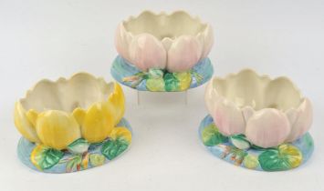 Three Clarice Cliff rose or flower bowls in the design of an open water lilly, two with pink grond