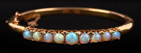 Opal and diamond hinged bangle, set with nine round cabochon cut opals and rose cut diamonds,