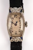 Diamond and sapphire cocktail watch, tonneau shaped face, with Arabic hour markers and a railway