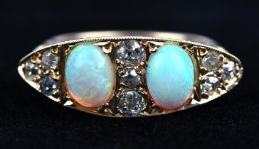 An antique opal and diamond carved half hoop ring, set with two oval cabochon cut opals weighing an