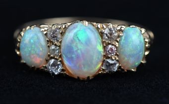 Opal and diamond ring, with three oval cabochon opals, and old cut diamonds, with carved sides,