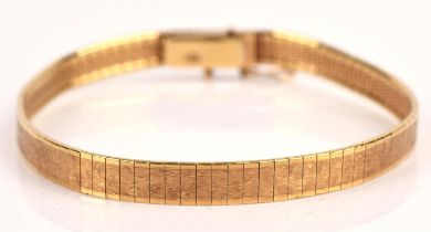 An articulated 18 ct gold bracelet, with a textured gold finish and polished edges,