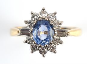 A sapphire and diamond cluster ring, central oval cut sapphire weighing an estimated 0.70 carats,