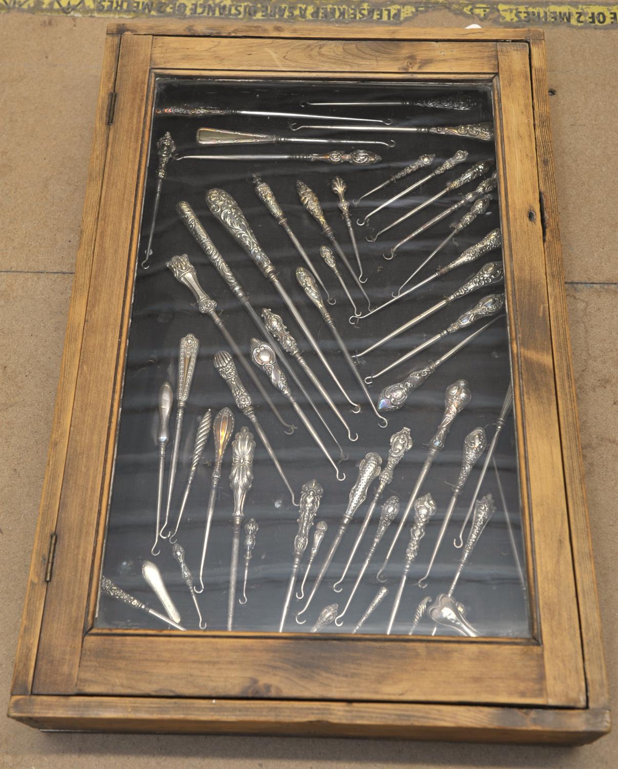 Three display cases, late 19th Century, displaying a large collection of silver button hooks, - Image 3 of 4