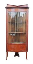An Edwardian mahogany and satinwood banded standing corner cabinet, with a bowed glazed and solid