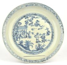 A heavily potted blue and white dish of circular form, decorated in the well with a narrative scene