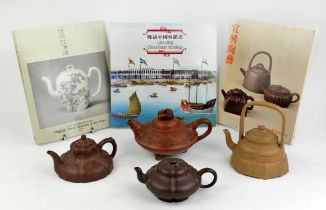Four Yixing teapots, the tallest about 14 cm high; together with three books from the Urban Council