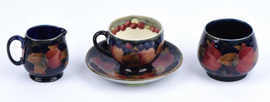 William Moorcroft, Pomegranate, a cup and saucer, signed and impressed marks to bases, the cup 6.