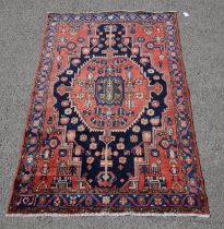 Hamadan carpet, with central octagonal medallion, stylised flowers on a brick red field,