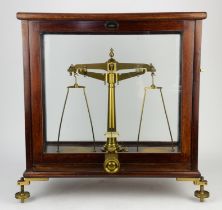 A brass balance, 20th Century, in a mahogany glazed case, with label for the Standards Department,
