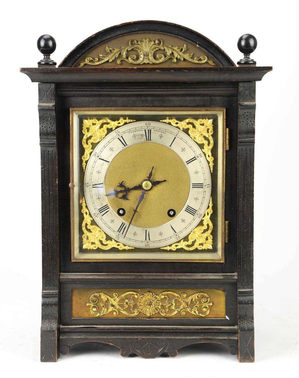 An ebonised wood clock, late 19th/early 20th Century, with ball finials and brass mounted scroll