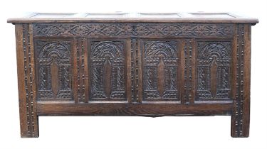 A Queen Anne oak panelled coffer, the hinged lid above a front with four later carved panels,