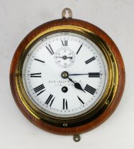 Brass bulkhead clock by John Lilley and Son, London, on an oak back, with key, the clock