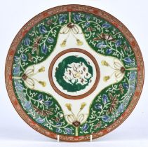A polychrome enamel dish of circular form with rouge-de-fer rim; decorated with foliage designs on