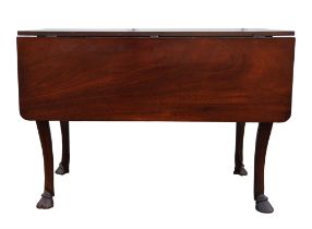 A George III mahogany twin flap dining table, with cabriole legs, terminating in hoof feet,