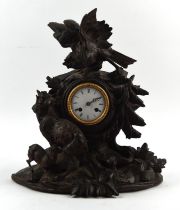 German Black Forest clock, 19th Century, carved with a bird and a pair of sheep, in a wooden