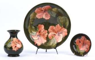 Moorcroft, Hibiscus in peach corals on green ground, a bowl, impressed marks to base and signed,