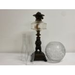 Vintage oil lamp with cast metal bear and base, damage repair to globe split wick - height 45cm