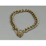 Heavy 9ct gold curb chain bracelet with heart padlock, 23cms 26.89g