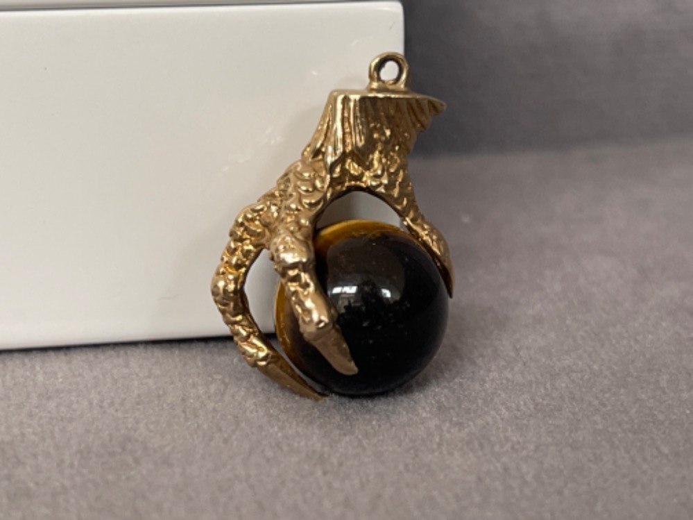 A unusual Eagle Claw Charm hold a tigers eye stone - weighing 5.06 grams