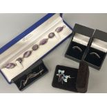 Five pieces of silver jewellery includes two cz rings, enamel & plain earrings and purple stone